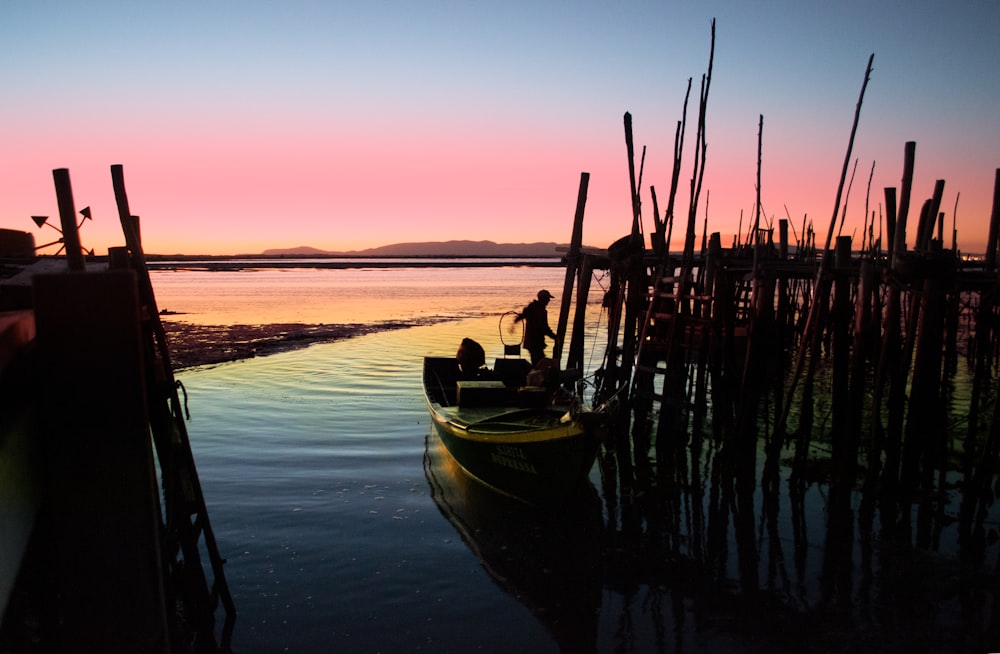 Gelbes und blaues Boot auf See bei Sonnenuntergang