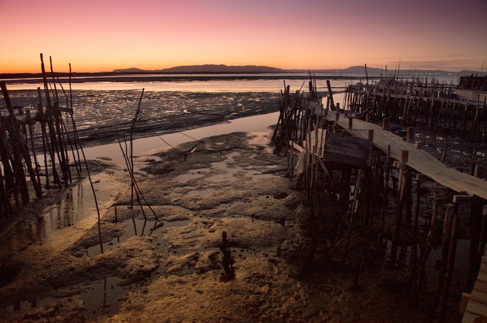 brown wooden dock on sea during sunset