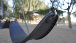 Close-up of a playground swing chain being lubricated.
