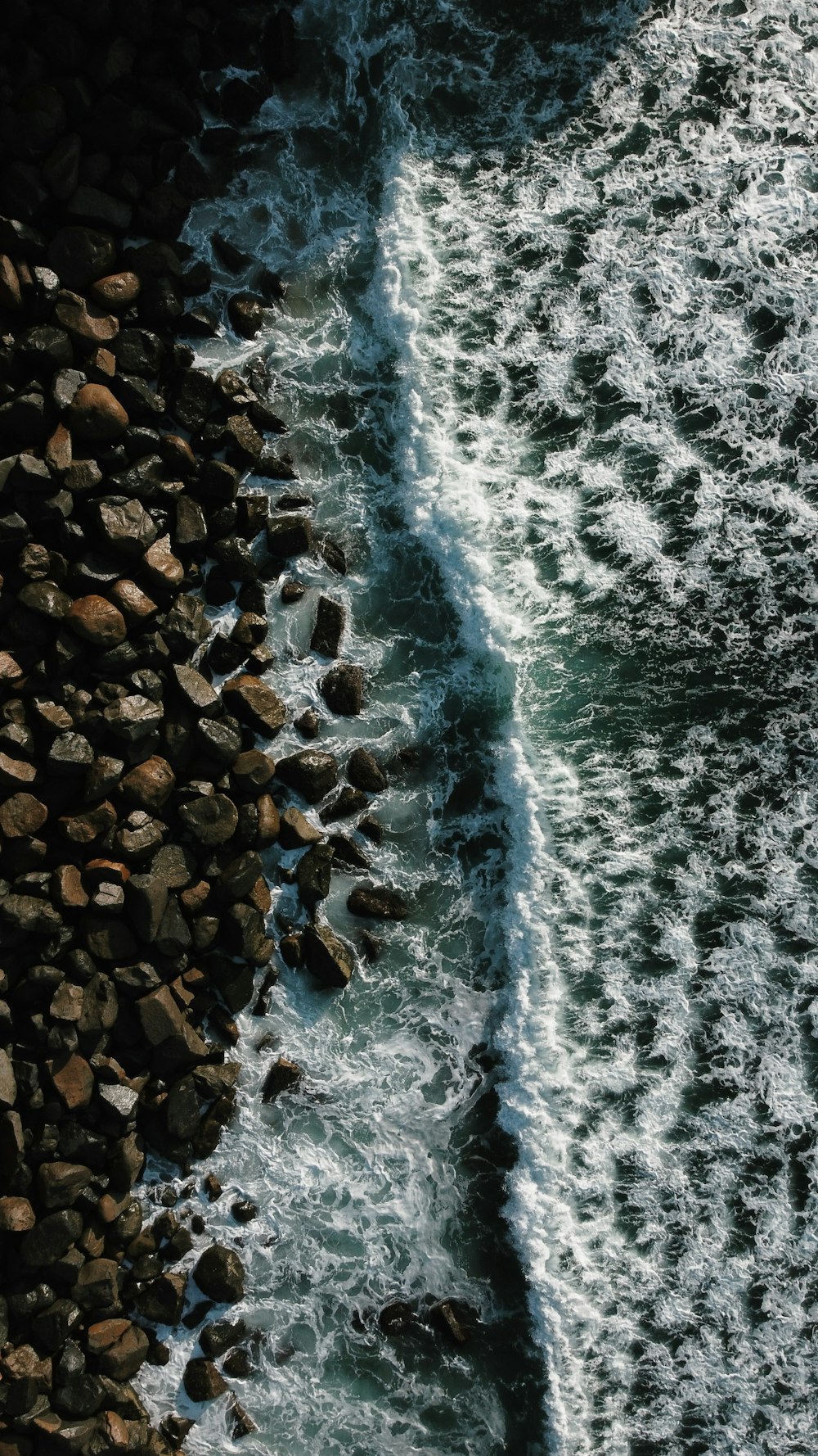 brown and black rocks on seashore