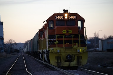 yellow and black train on rail tracks during daytime