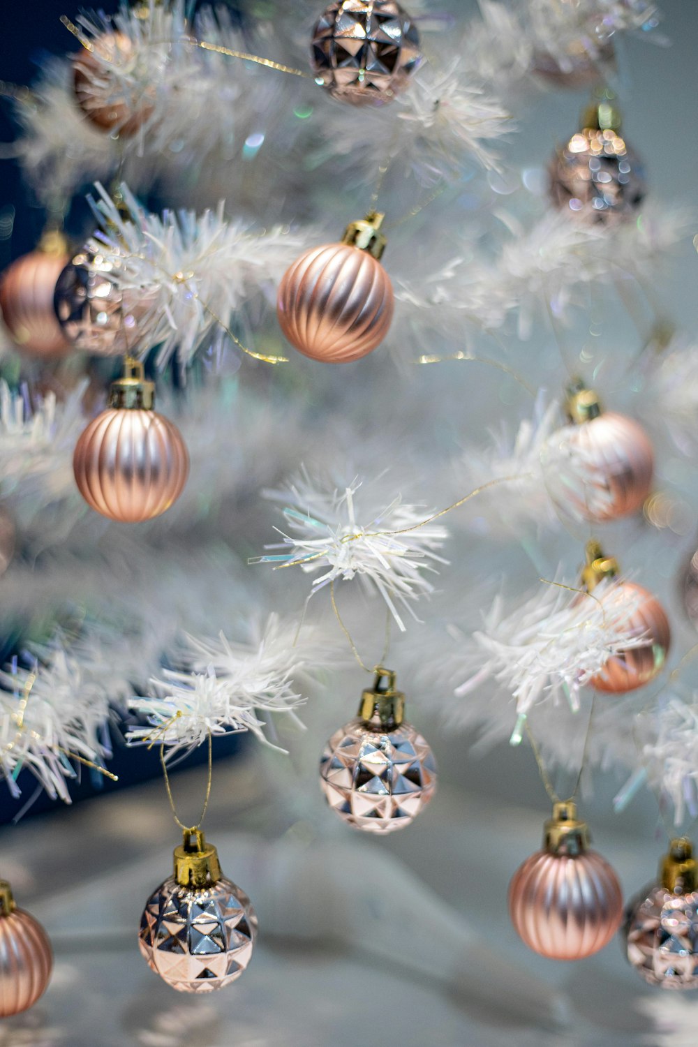 Bolas blancas y doradas en árbol de Navidad blanco