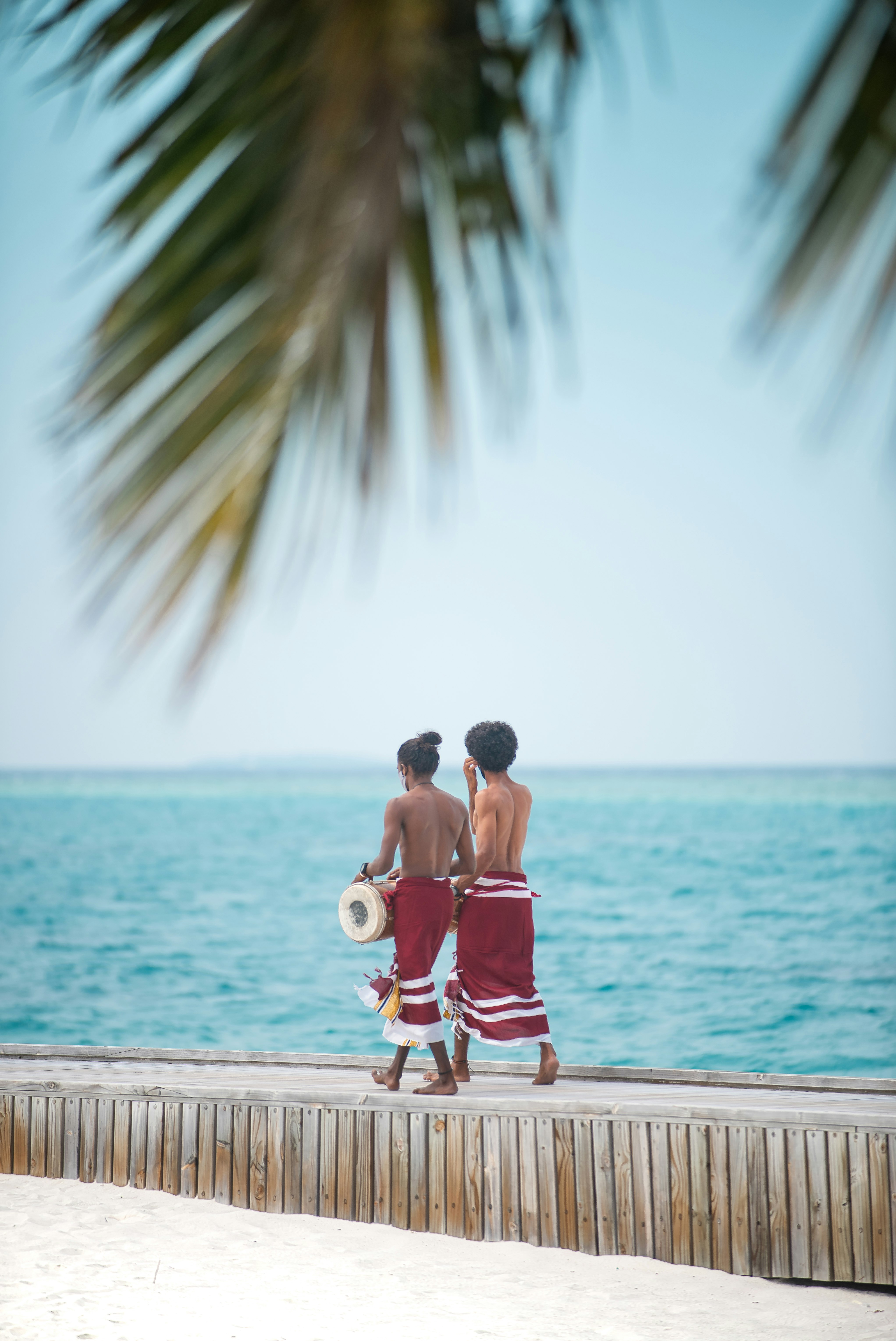 man in red shorts and white shirt holding a child in white shirt and red shorts