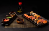 Overhead shot of a vibrant sushi platter with red and gold garnishes.