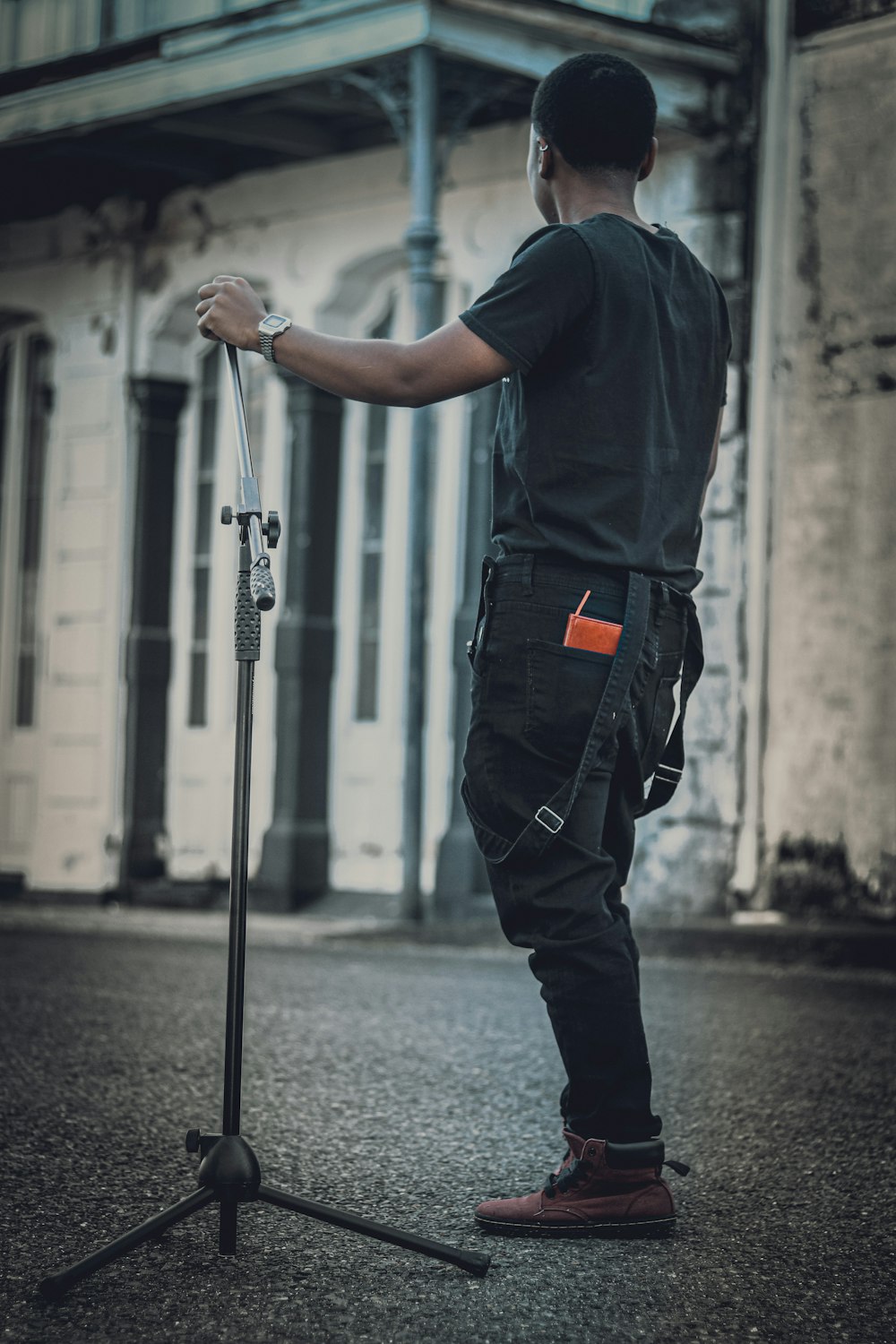 man in blue t-shirt and black pants holding black metal rod