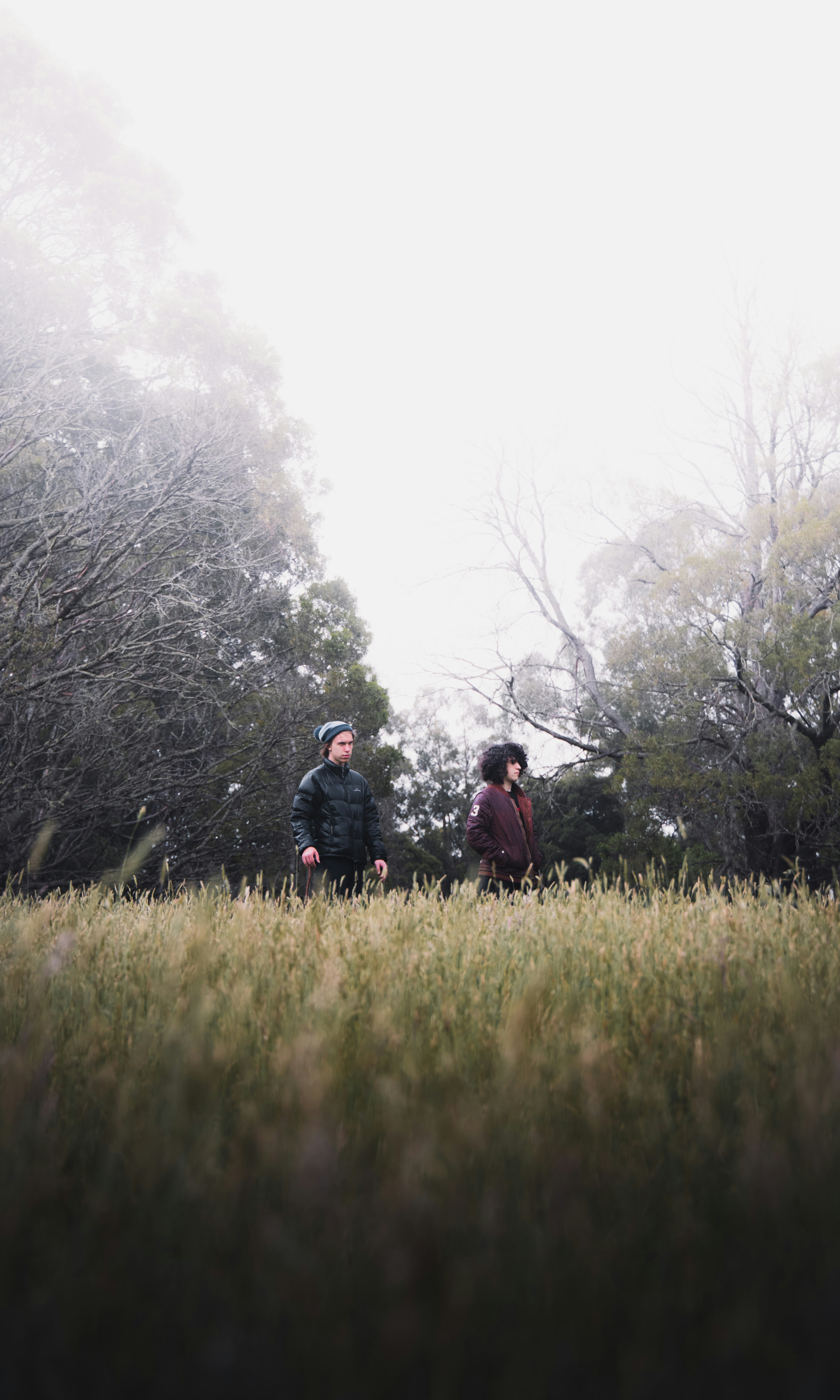 man and woman standing on green grass field during daytime