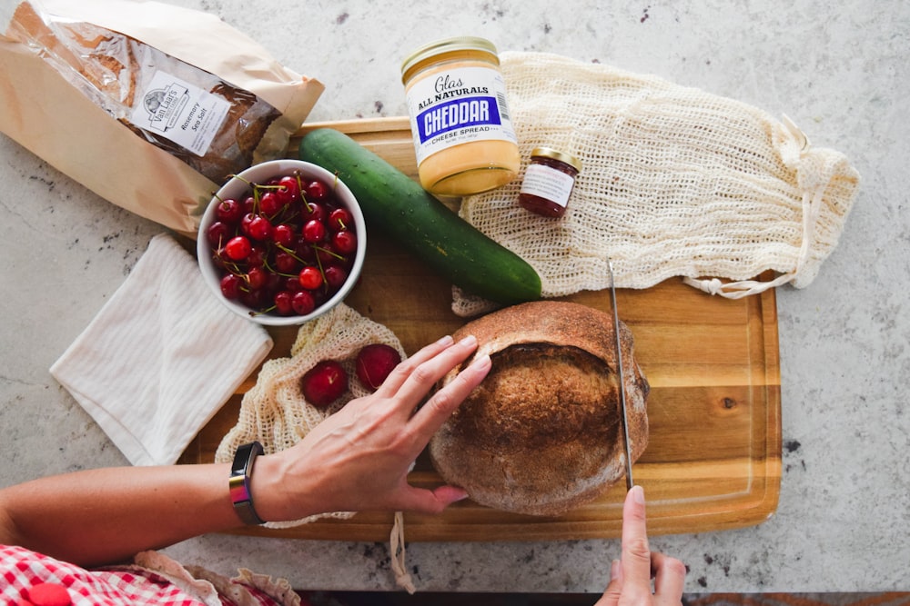 Person, die grünes Gemüse und Schwarzbrot hält