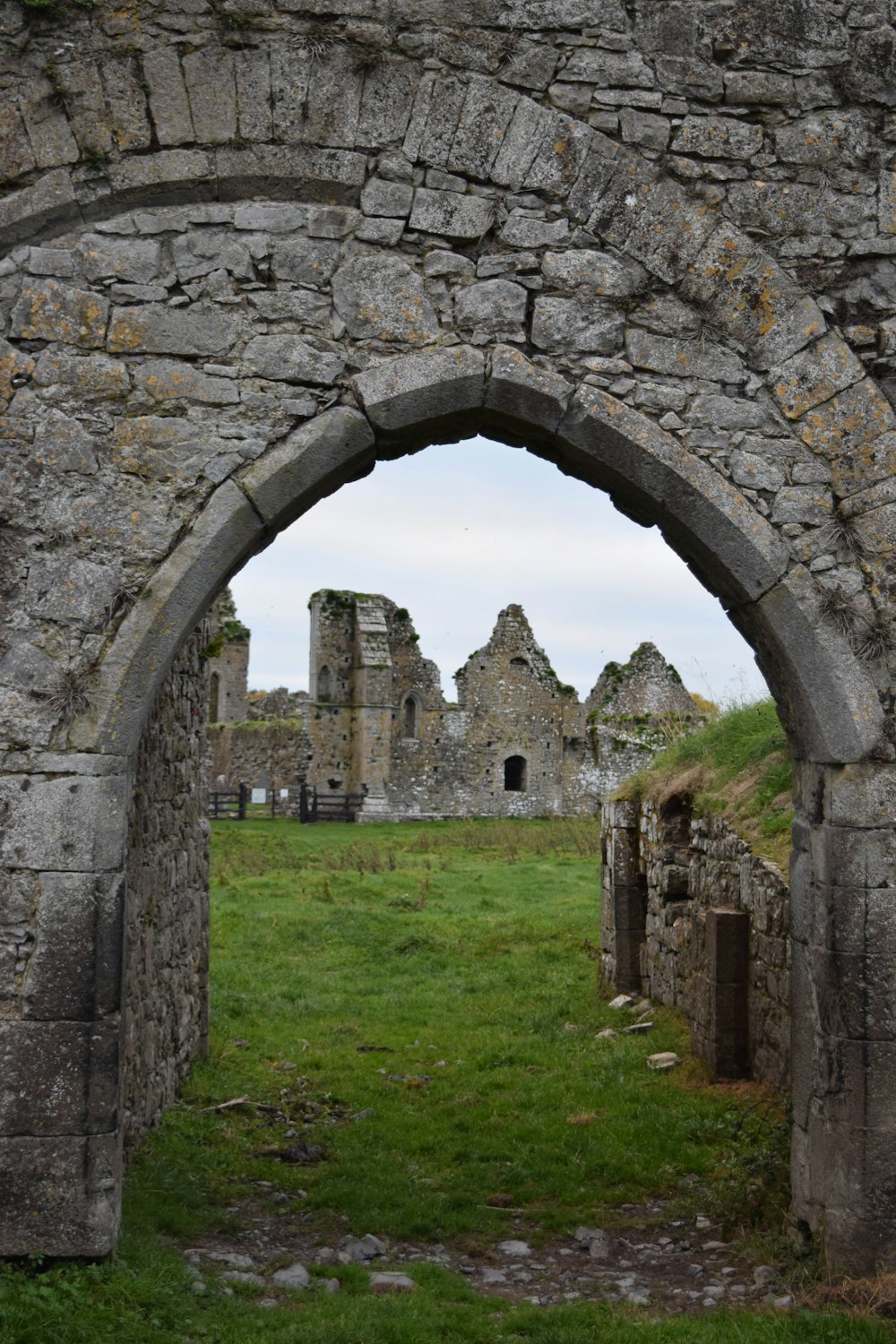 grey concrete arch on green grass field during daytime