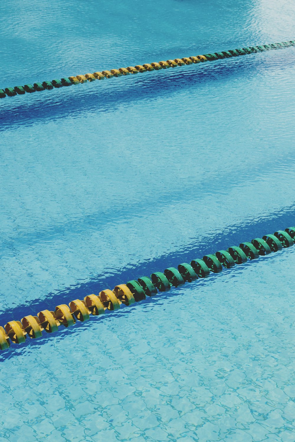 blue swimming pool with yellow and black beaded bracelets