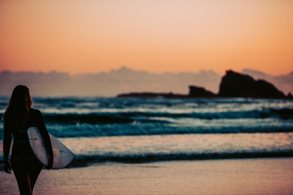 tenda de praia branca e marrom na praia durante o pôr do sol
