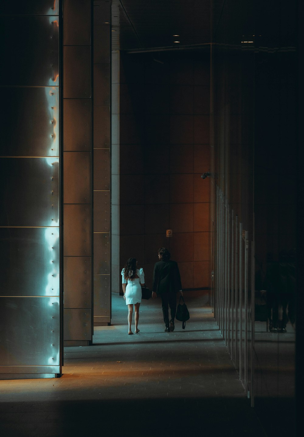 man and woman walking on sidewalk during night time