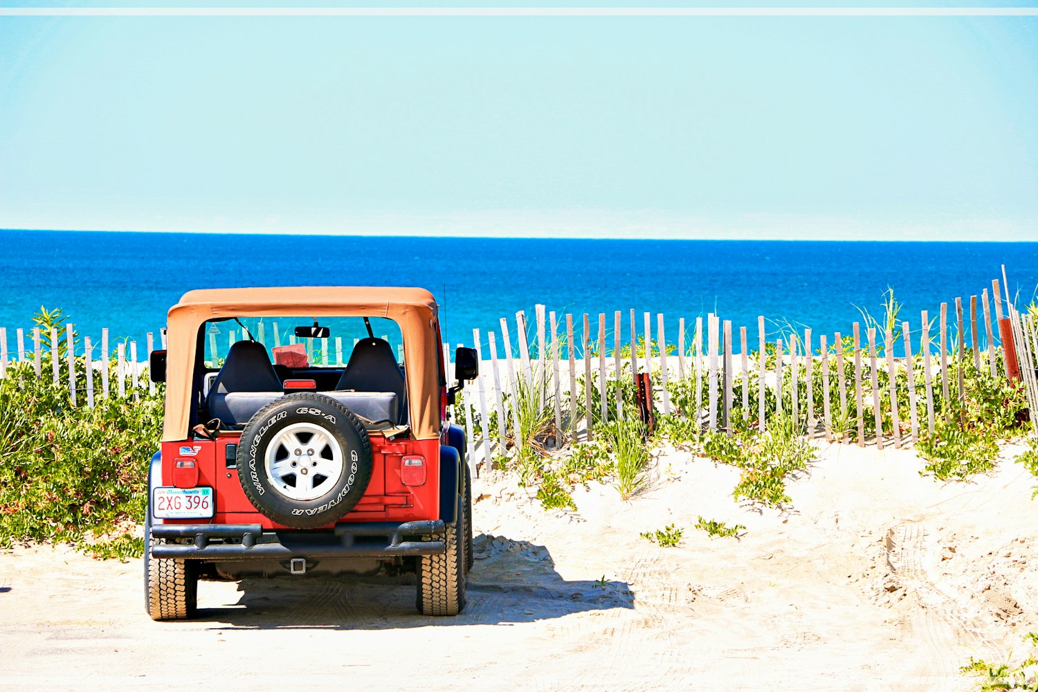 Jeep with Massachusetts plates parked near a beach.