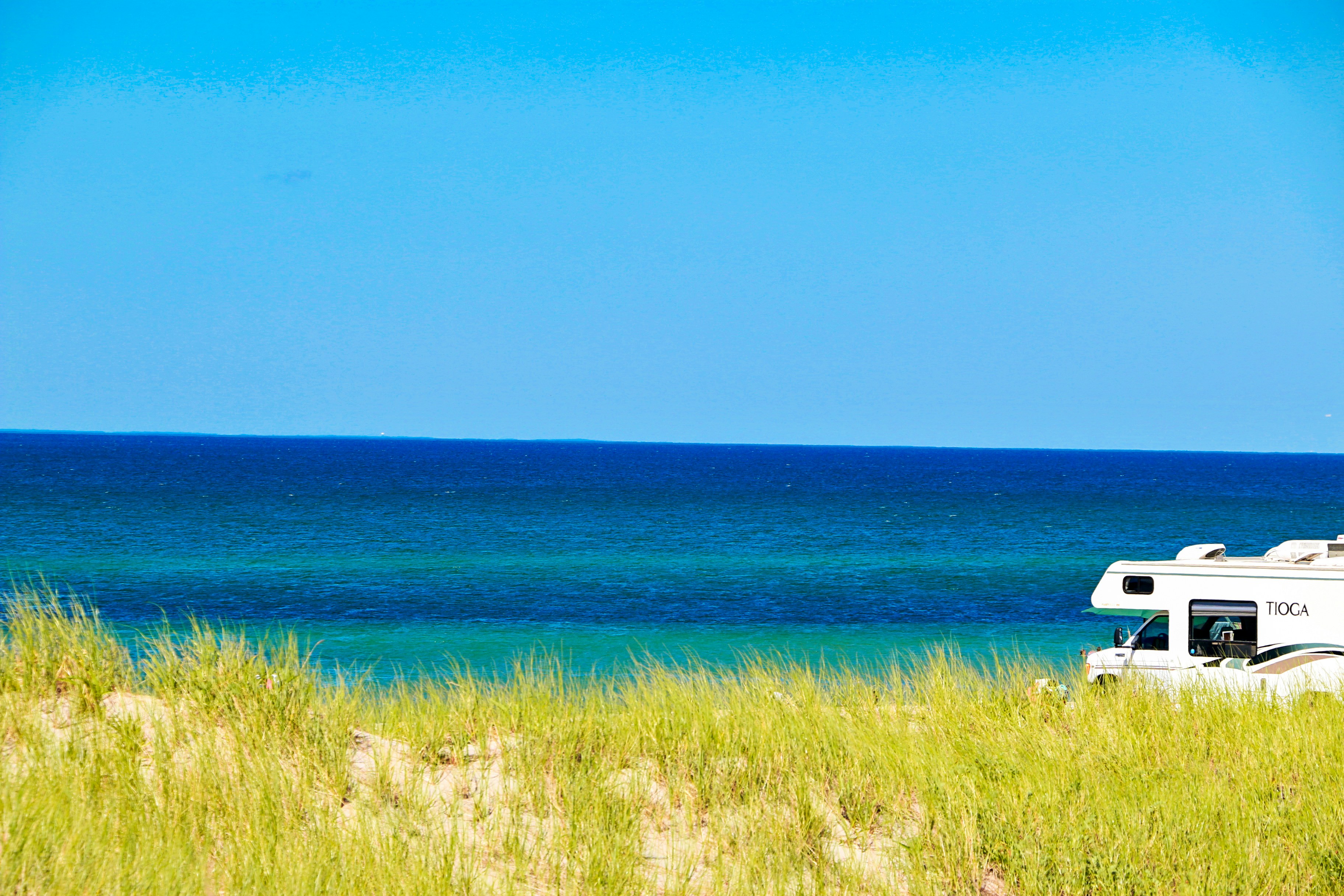 green grass near blue sea under blue sky during daytime cape cod zoom background