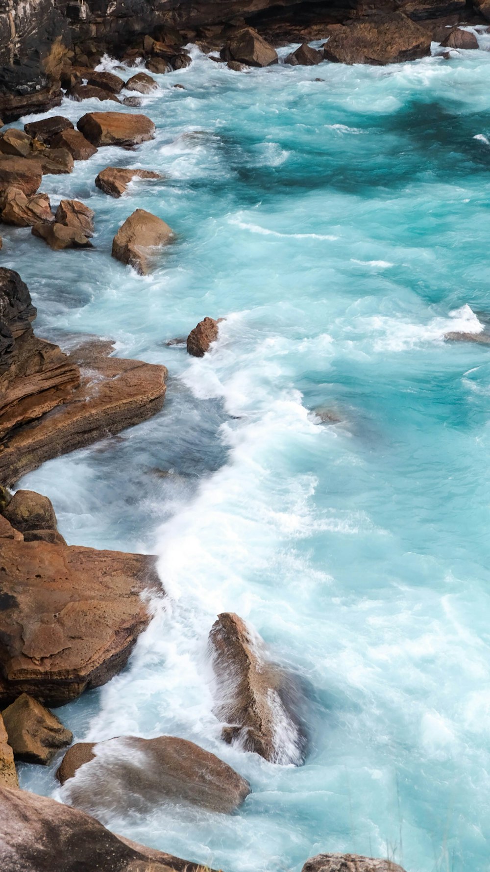 brown rock formation near body of water during daytime