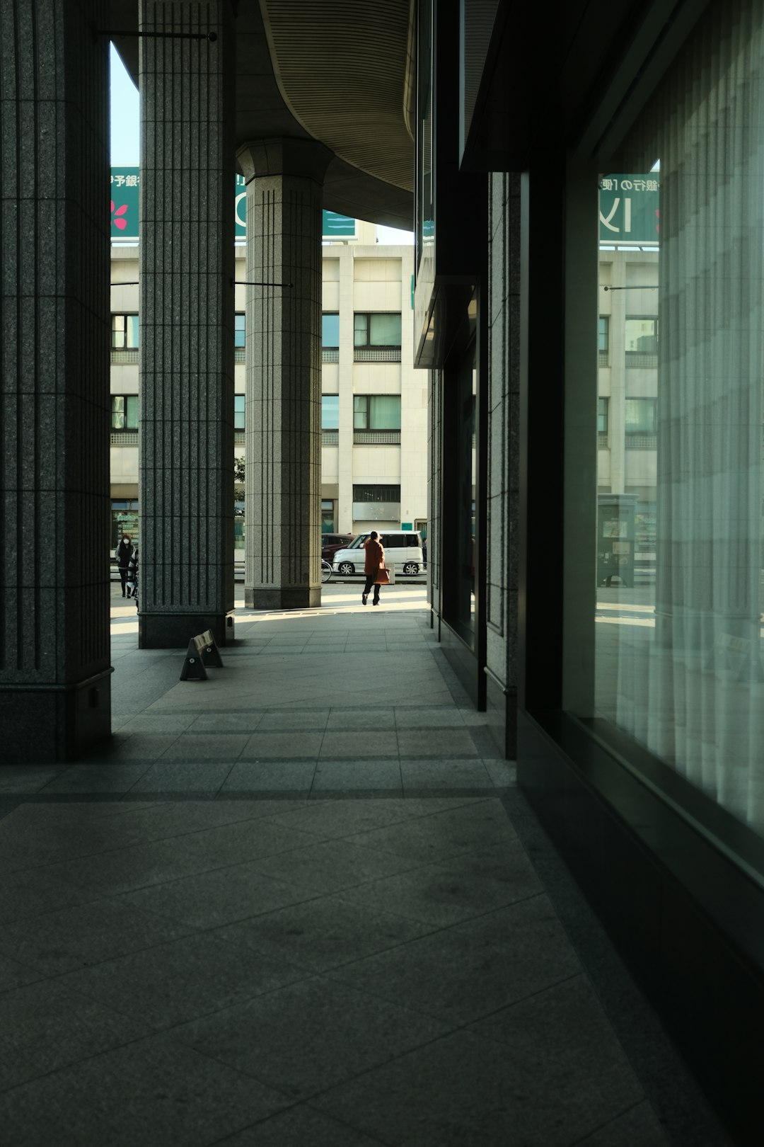 people walking on sidewalk near glass building during daytime