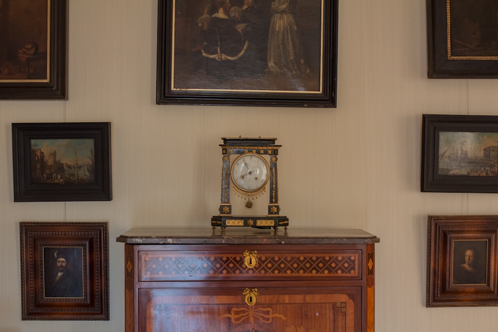 a clock sitting on top of a wooden dresser