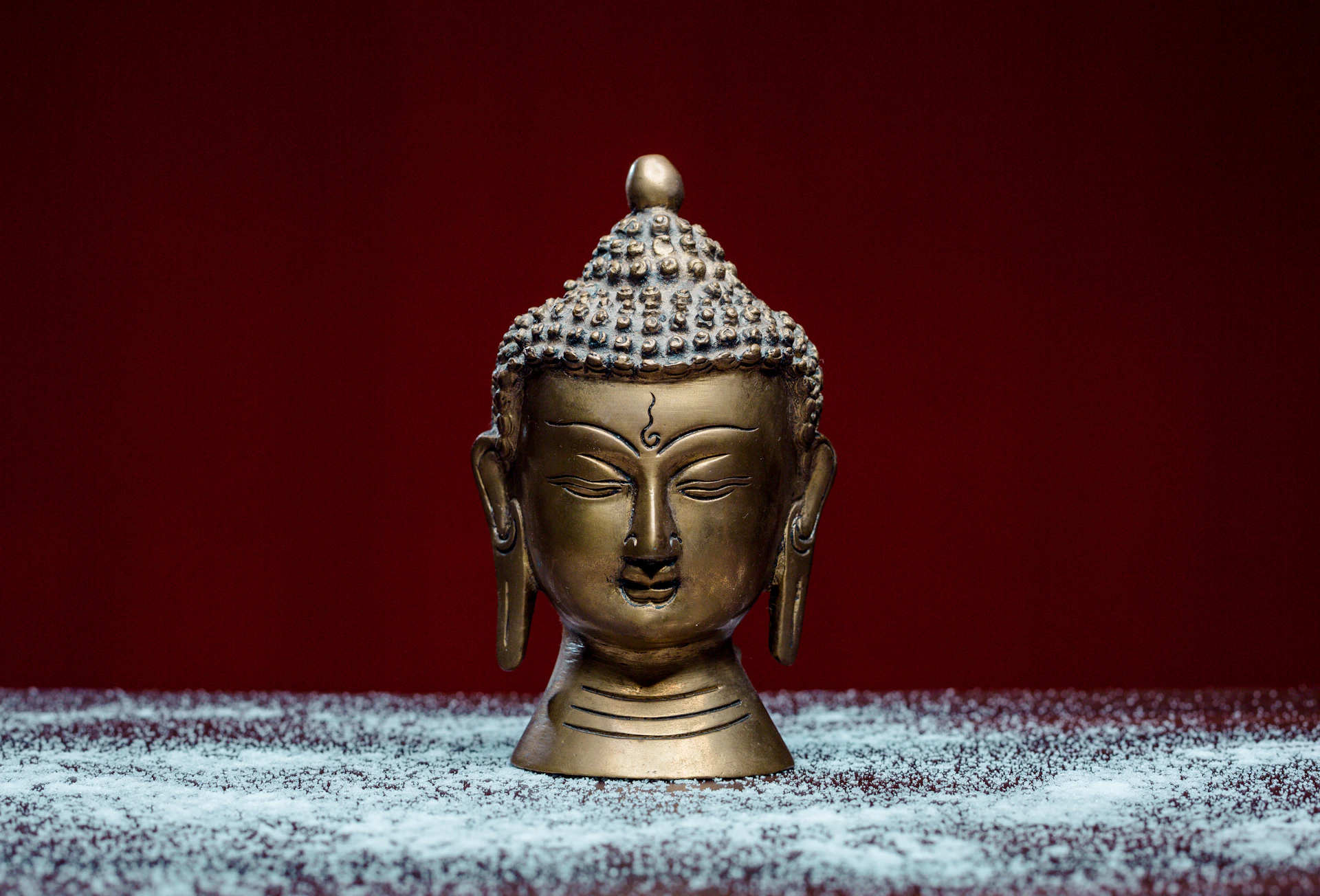 gold buddha figurine on white and blue textile