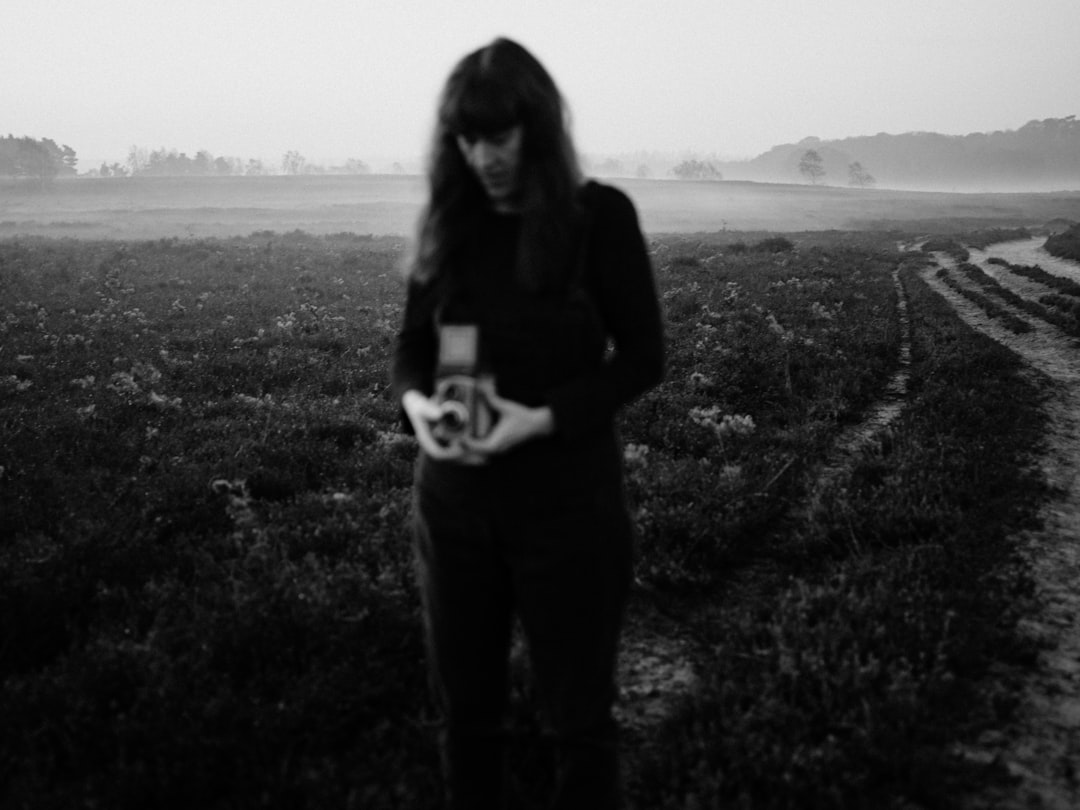 woman in black long sleeve shirt standing on grass field