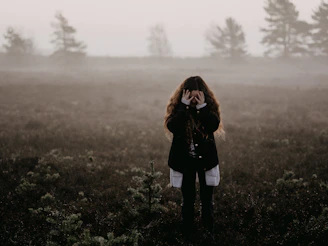 woman in black jacket standing on grass field