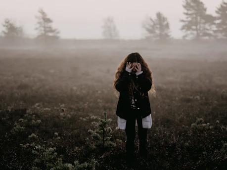 woman in black jacket standing on grass field