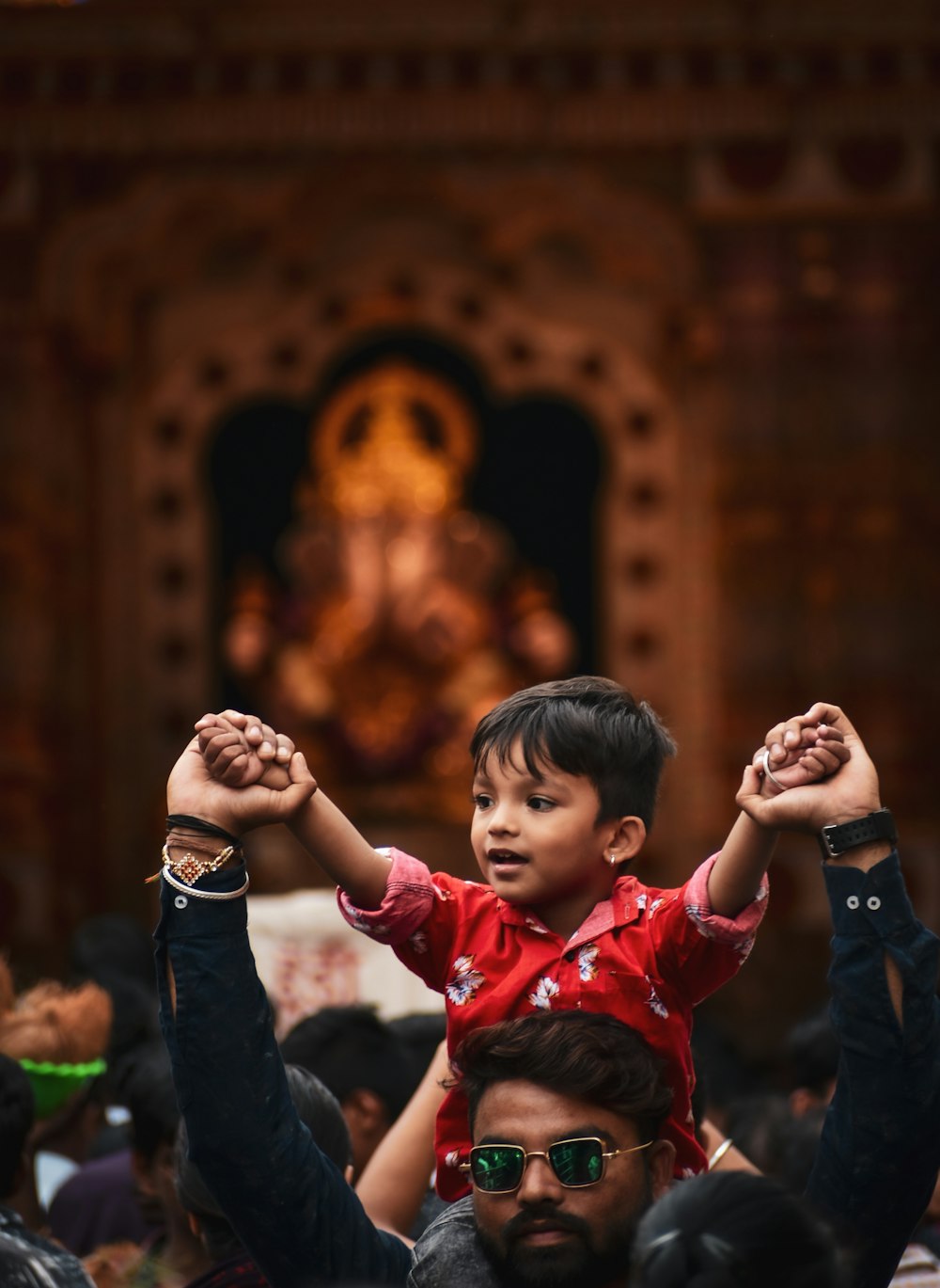 boy in red long sleeve shirt standing beside man in black jacket