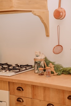 A cozy kitchen corner with essential oils and sleek cookware displayed.