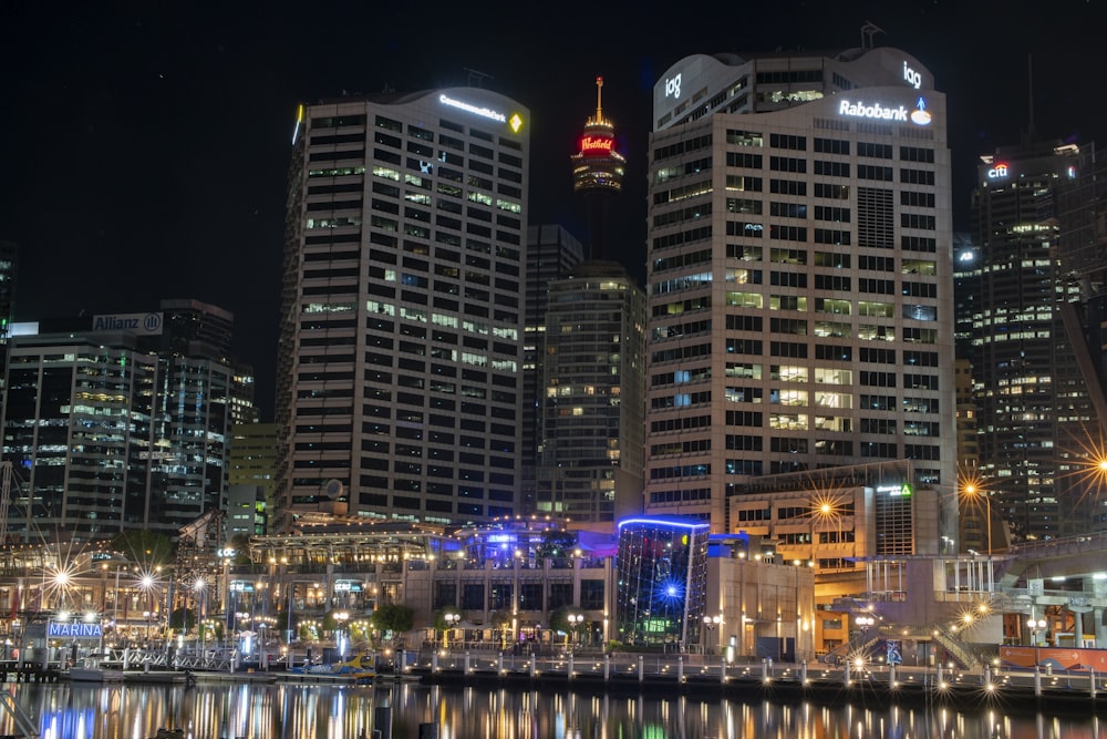 city buildings near body of water during night time