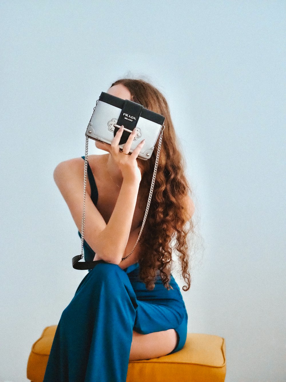 Femme en robe bleue sans manches tenant un appareil photo blanc et noir