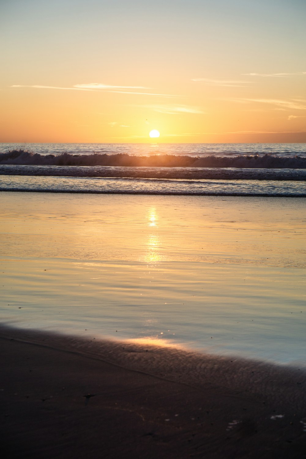 sea waves crashing on shore during sunset