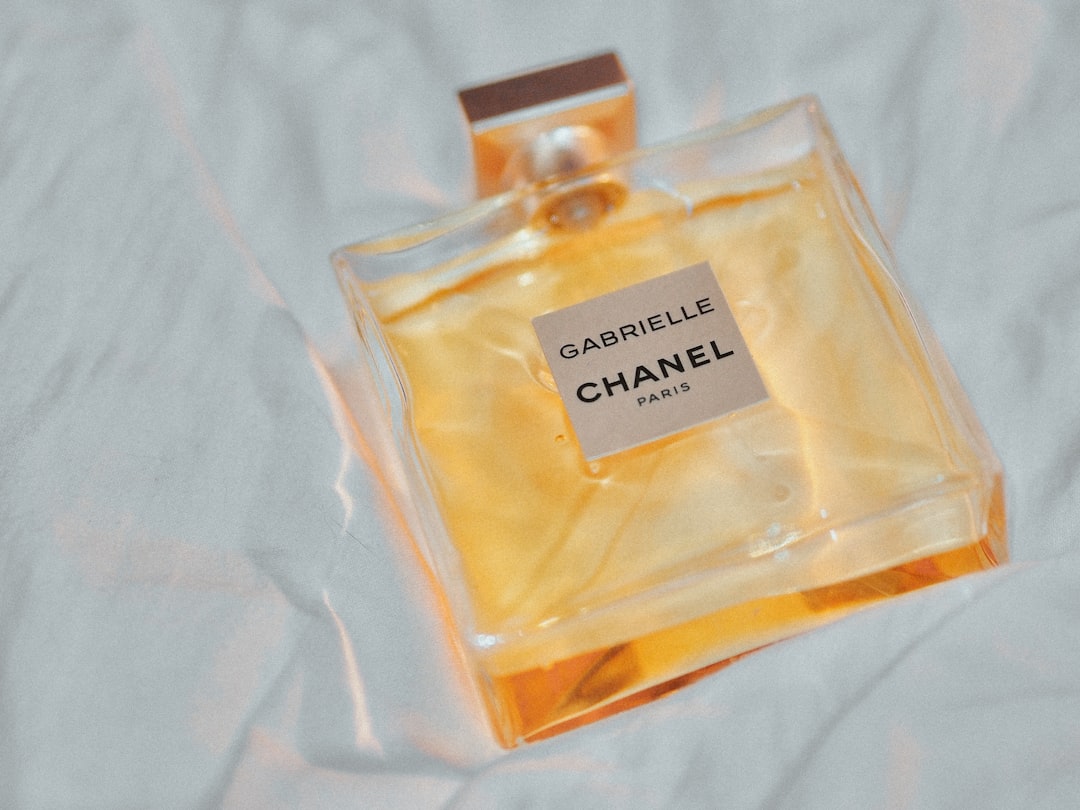 clear glass perfume bottle on white textile,
