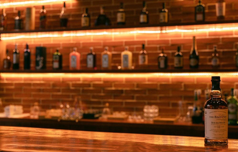 Foto de botellas de vidrio transparente en un estante de madera marrón –  Imagen gratuita Vino en Unsplash