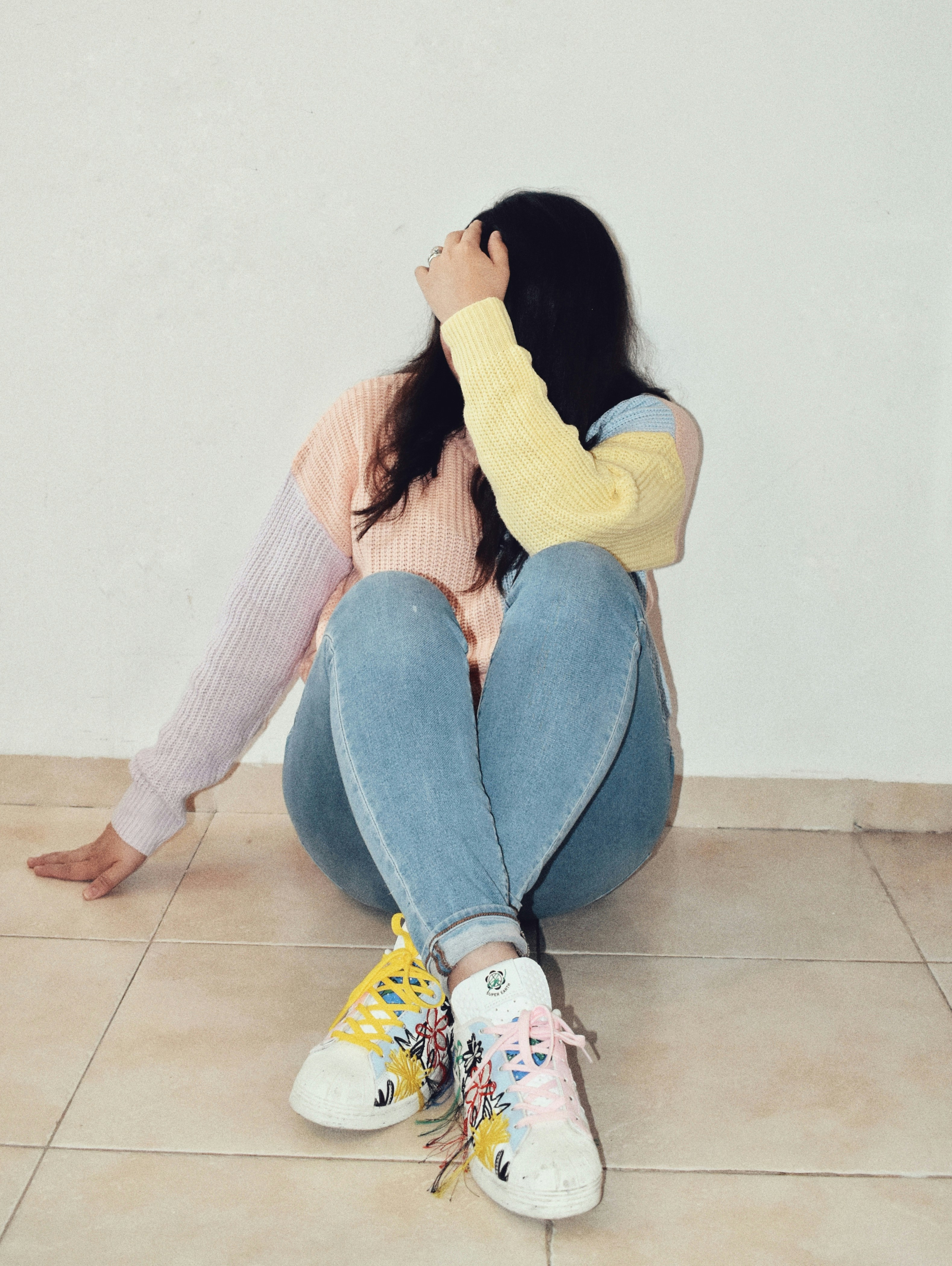  A collage of sneakers in pastel shades placed against a backdrop of spring flowers, highlighting the trend of soft, seasonal colors. 