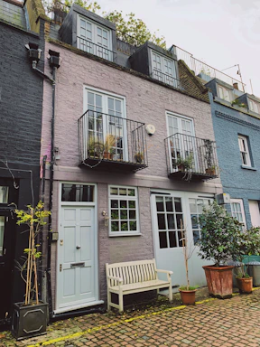 white wooden armchair beside purple concrete building