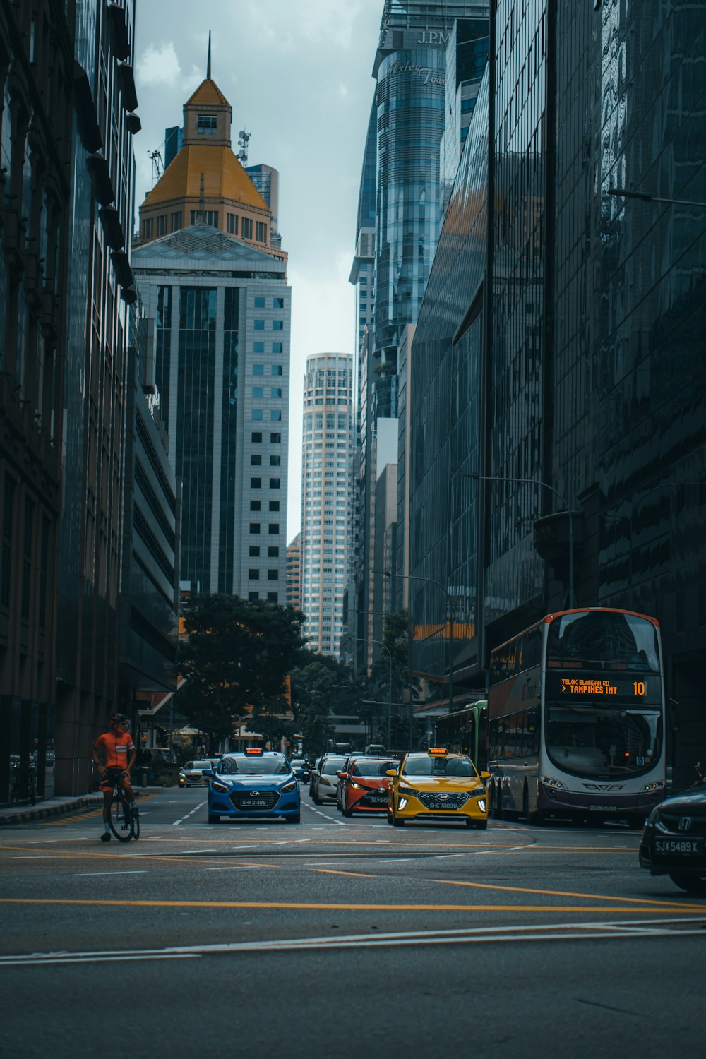 cars on road between high rise buildings during daytime