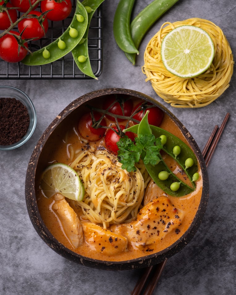 a bowl of curry and fresh vegetables over noodles|500