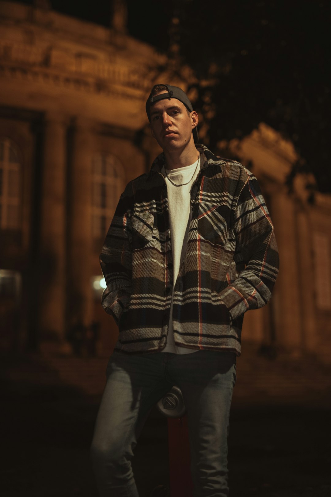 man in black and white plaid jacket standing during night time