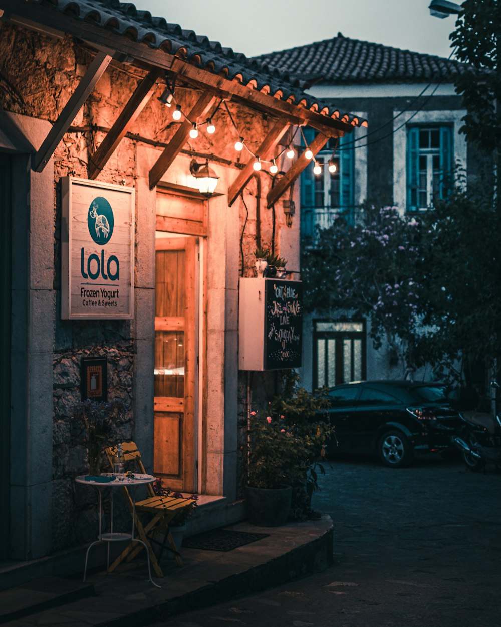 black car parked beside brown wooden building during night time