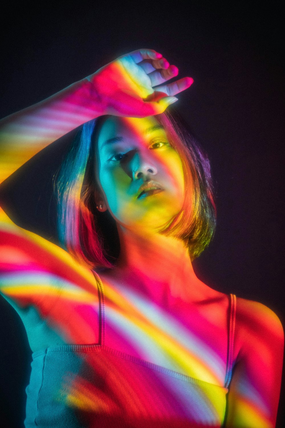 woman in pink tank top with green blue and purple lights