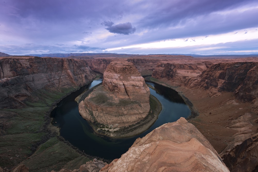 brown rock formation near body of water under blue sky during daytime