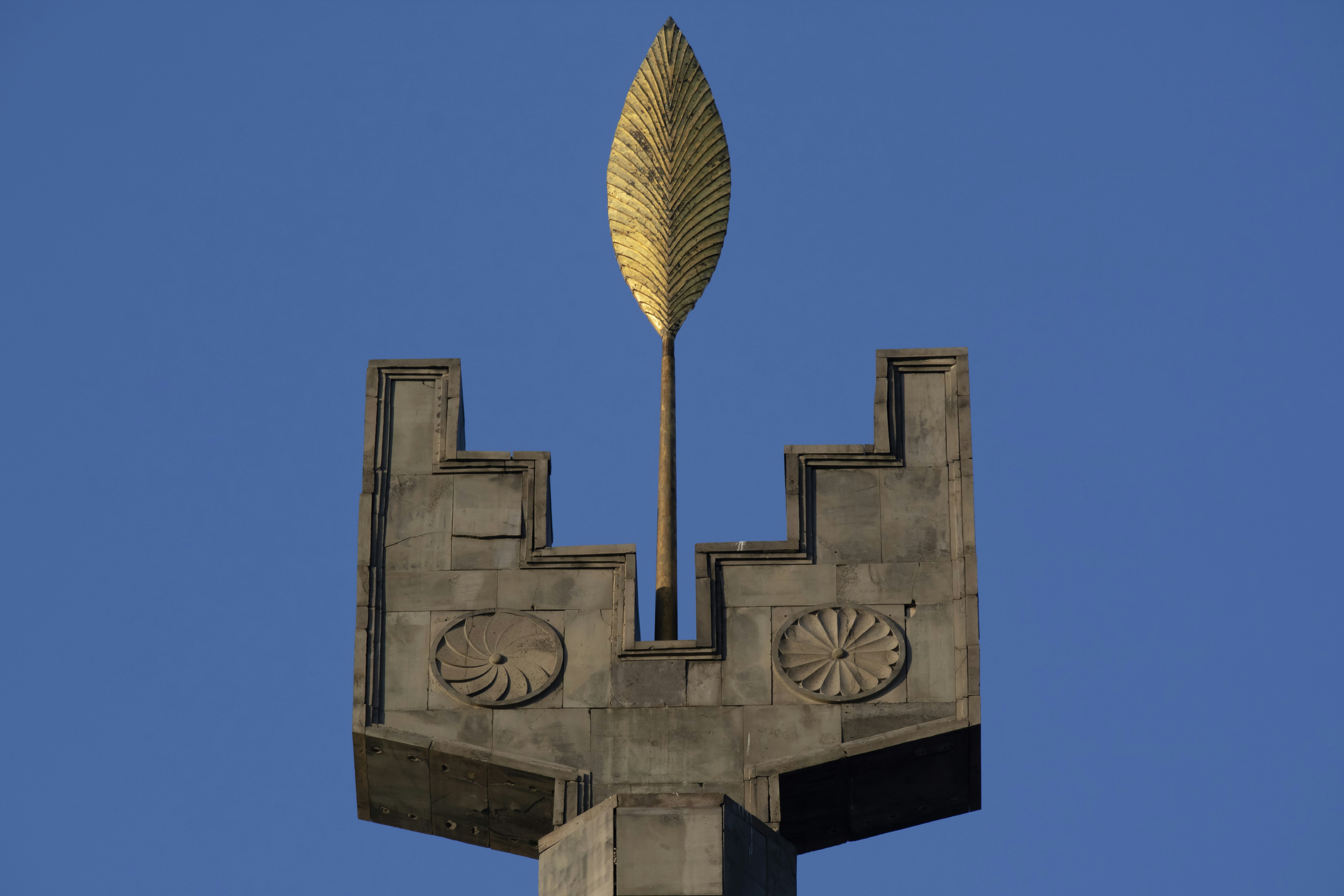 Croce in cemento grigio con ombrello dorato