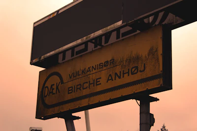 A close-up of a 'We Buy Junk Cars' sign with a Miami Lakes street in the background.