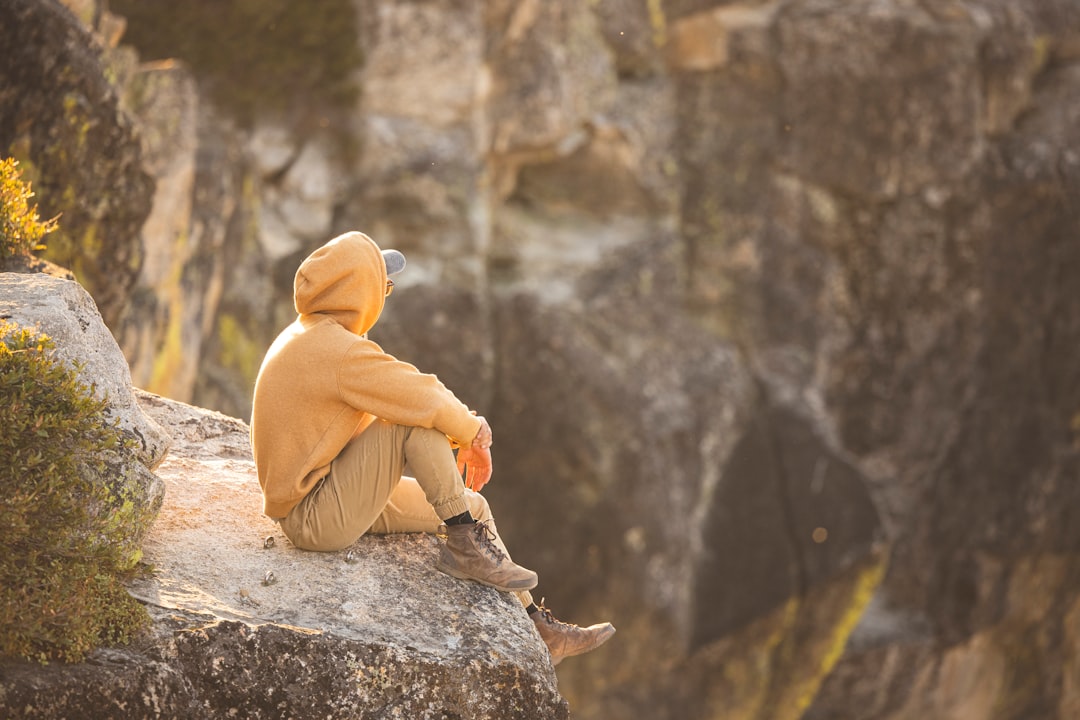 woman in yellow hijab sitting on rock