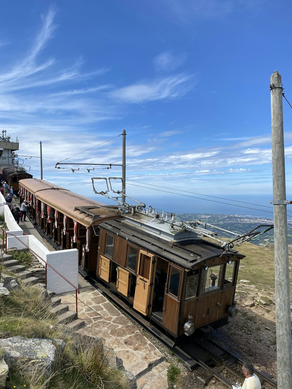 treno marrone e bianco sulla strada ferroviaria sotto il cielo blu durante il giorno