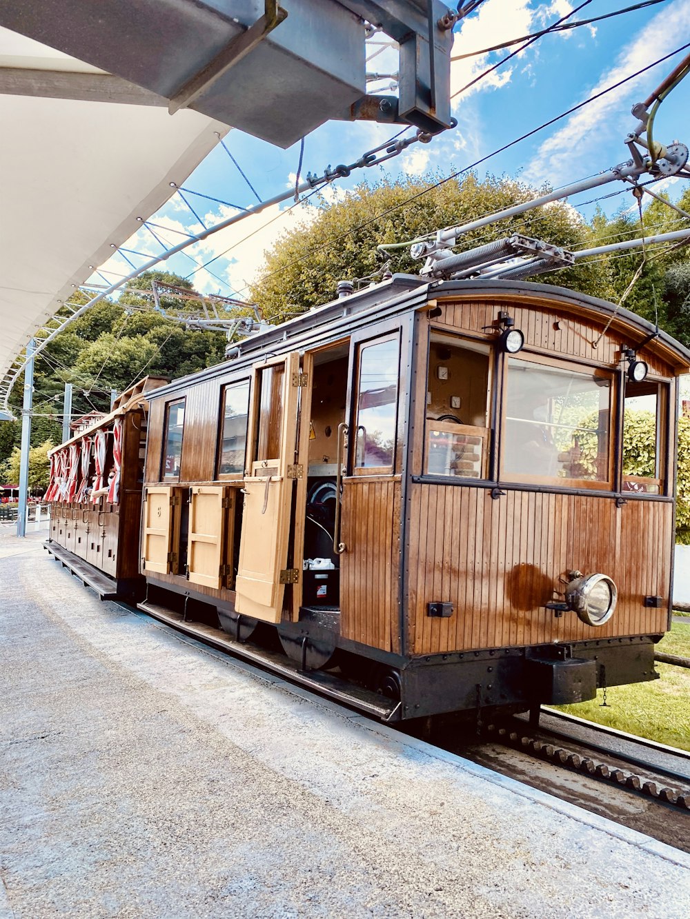 brown and black train under white clouds during daytime