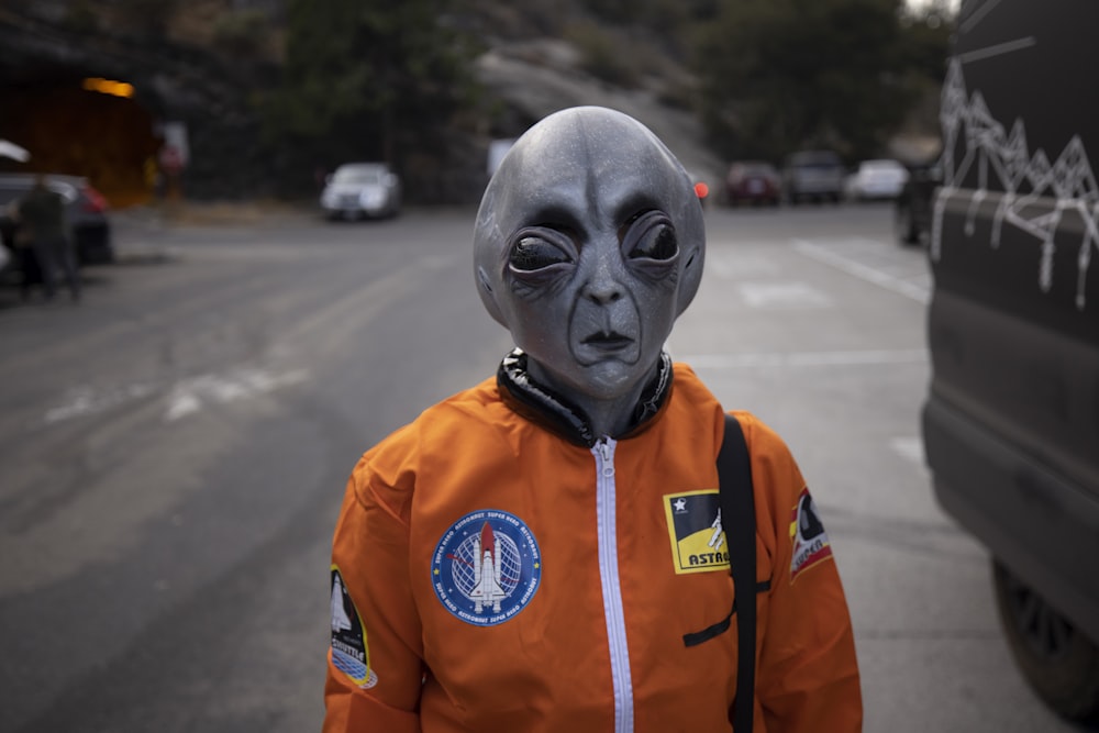 man in orange and white zip up jacket wearing white mask