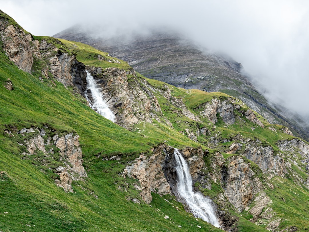 waterfalls on green grass covered mountain
