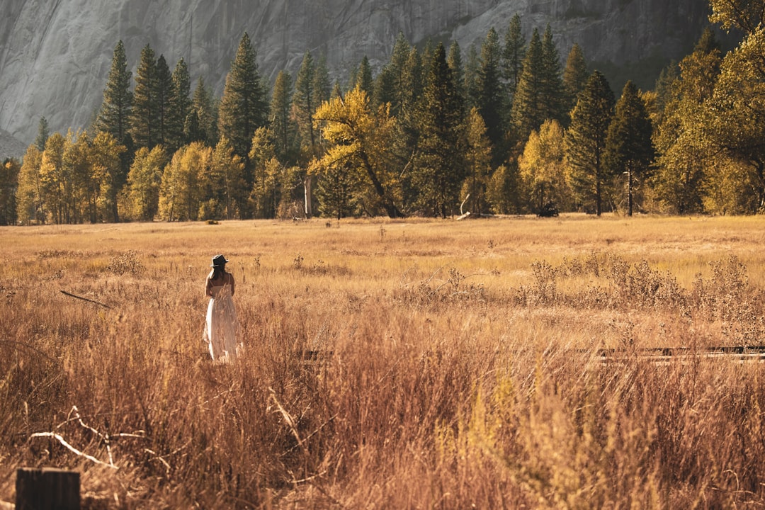 woman in black jacket standing on brown grass field during daytime