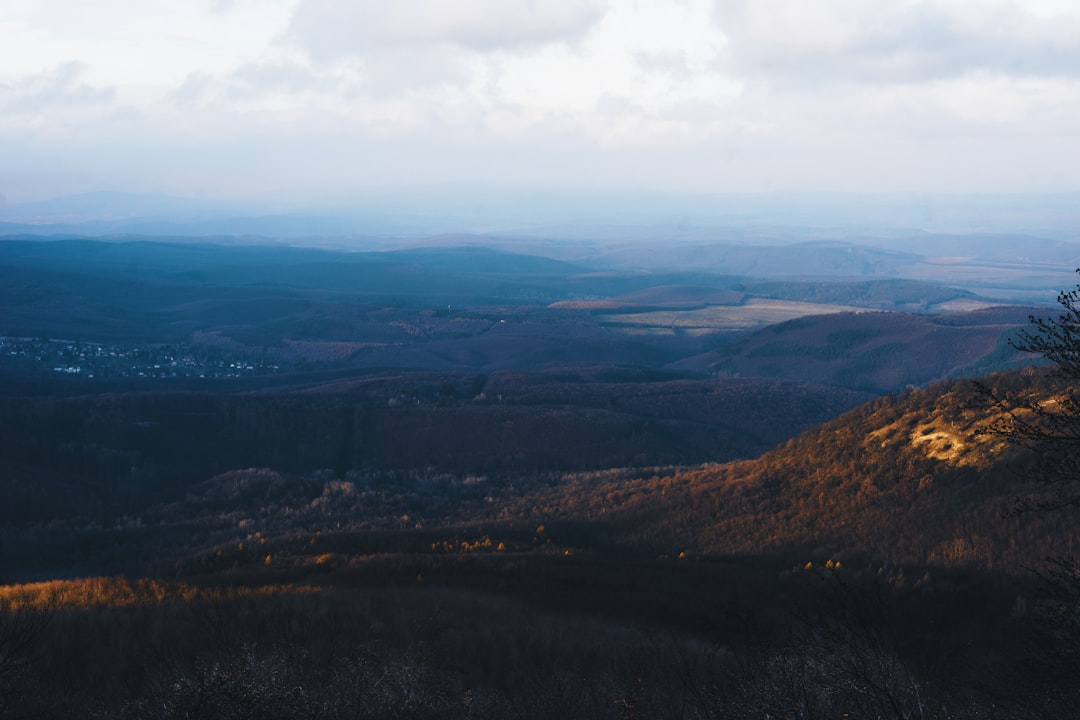 aerial view of green mountains under cloudy sky during daytime