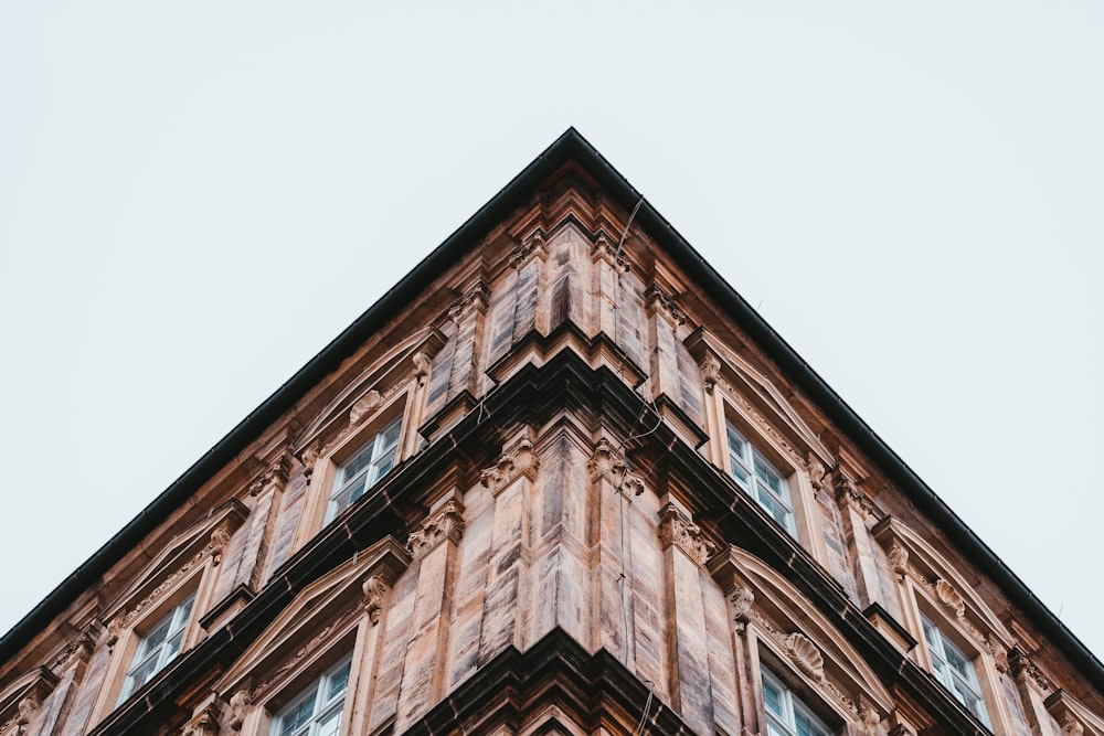 Edificio de hormigón marrón bajo el cielo blanco durante el día