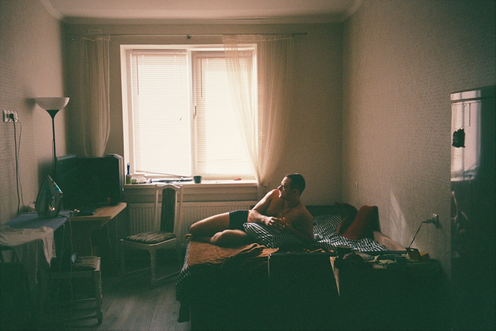 man in black shorts sitting on brown couch